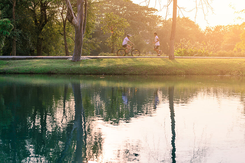 peaceful lake with water reflections and a man biking along